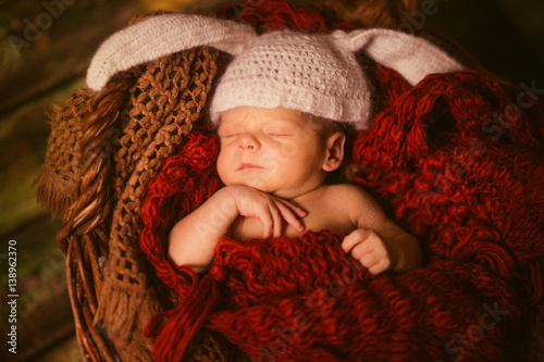 Pretty newborn child sleeps in white hat with rabbit ears photo