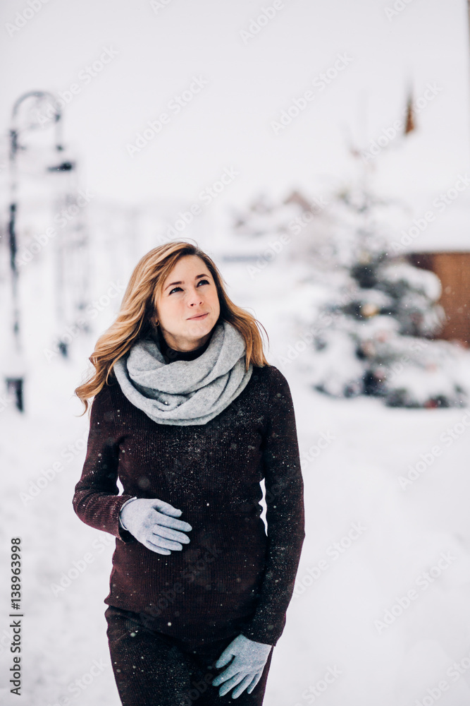 Thoughtful pregnant woman walks under falling snow Thoughtful pregnant woman walks under falling snow
