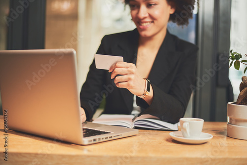 Mixed race woman in coffee shop having coffee and smiling