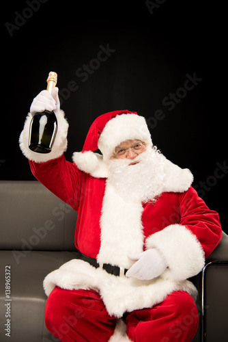 Santa Claus holding bottle of champagne