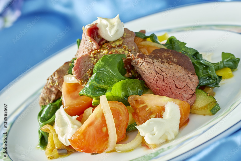 meat salad with green tomatoes on the plate blue background lot of food recipes