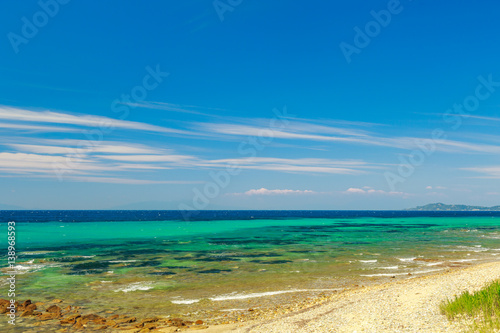 The rocky coast overlooking the turquoise blue and green sea in a warm summer day.