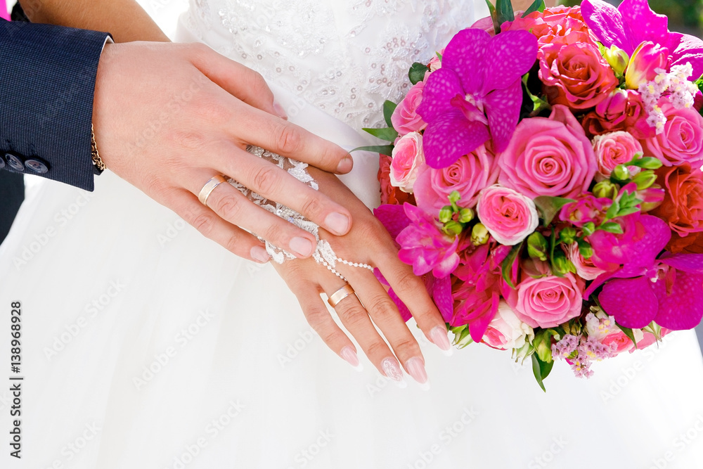 Hands with wedding rings on the background of white bridesmaid dresses Hands with wedding rings on the background of white bridesmaid dresses