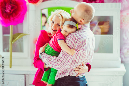 Charming little girl hugs father tender and mother hugs them both © pyrozenko13