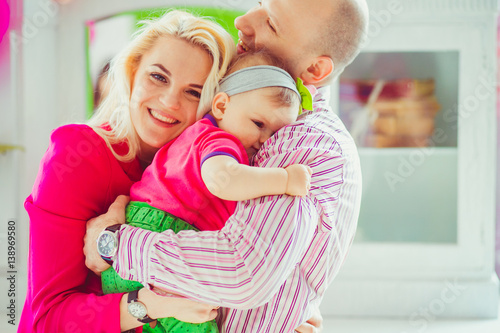 Man holds tender his little daughter and beautiful wife