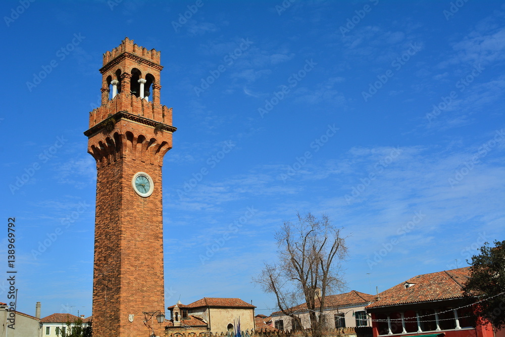 The bell tower with clock on the beautiful island of Murano in Venice, Italy