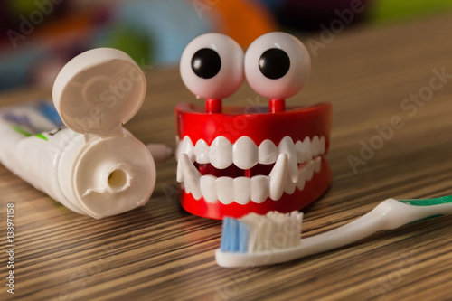 Set of complete denture;frontal view of upper and lower removable prosthesis and the grey toothbrush with toothpaste to clean