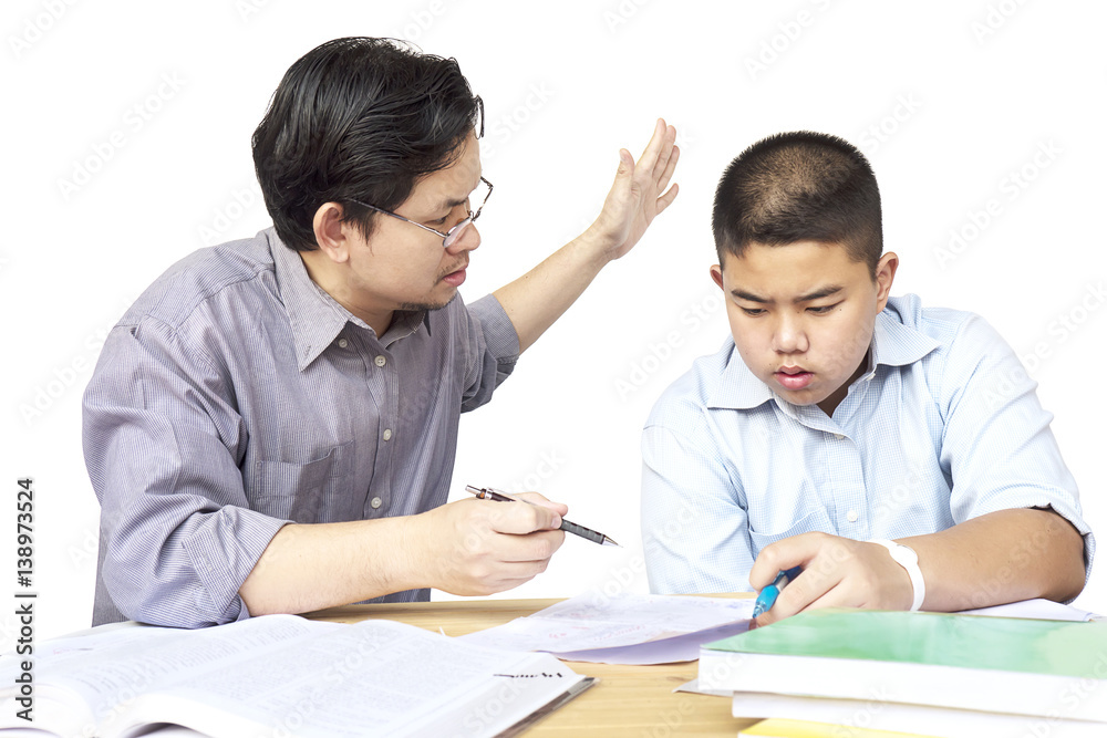 Asian father teaching homework to his 14 years son seriously Asian father teaching homework to his 14 years son seriously