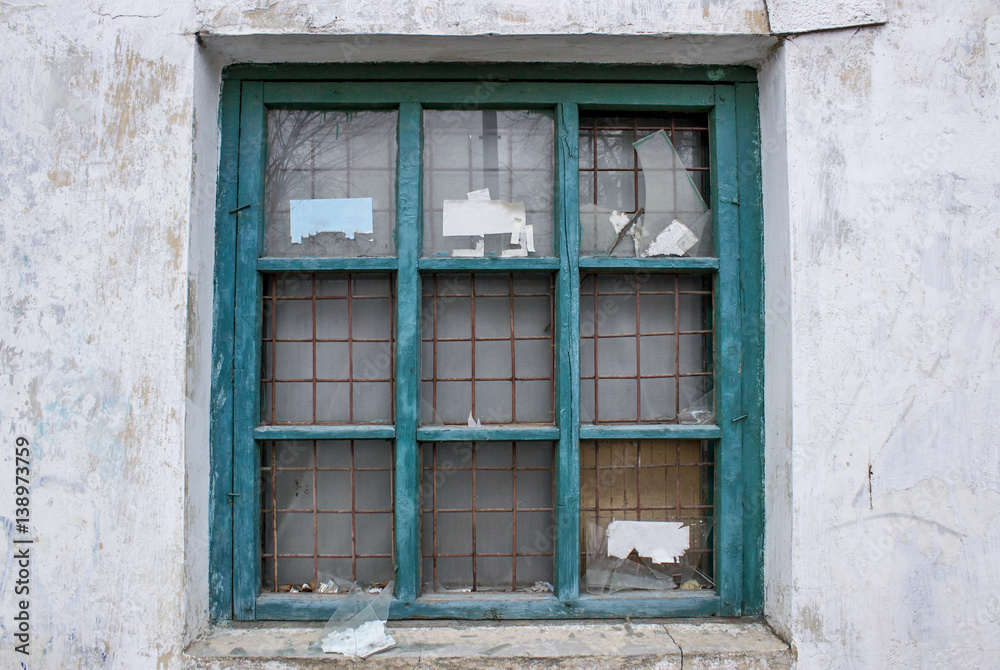 Old broken window with rusty iron bars