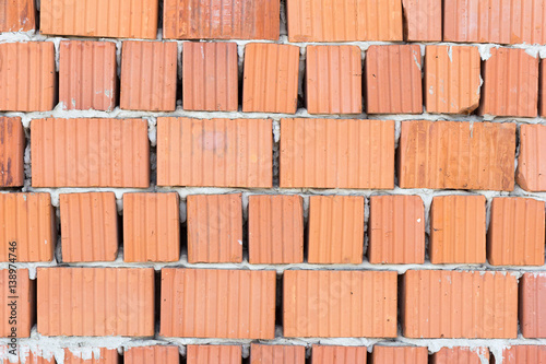 Bare wall of red bricks with no plaster