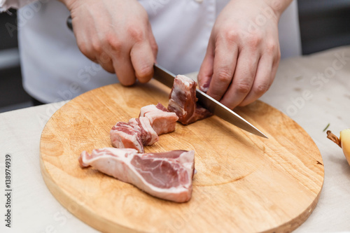 Chef Cutting Raw Meat on The Wood Block.