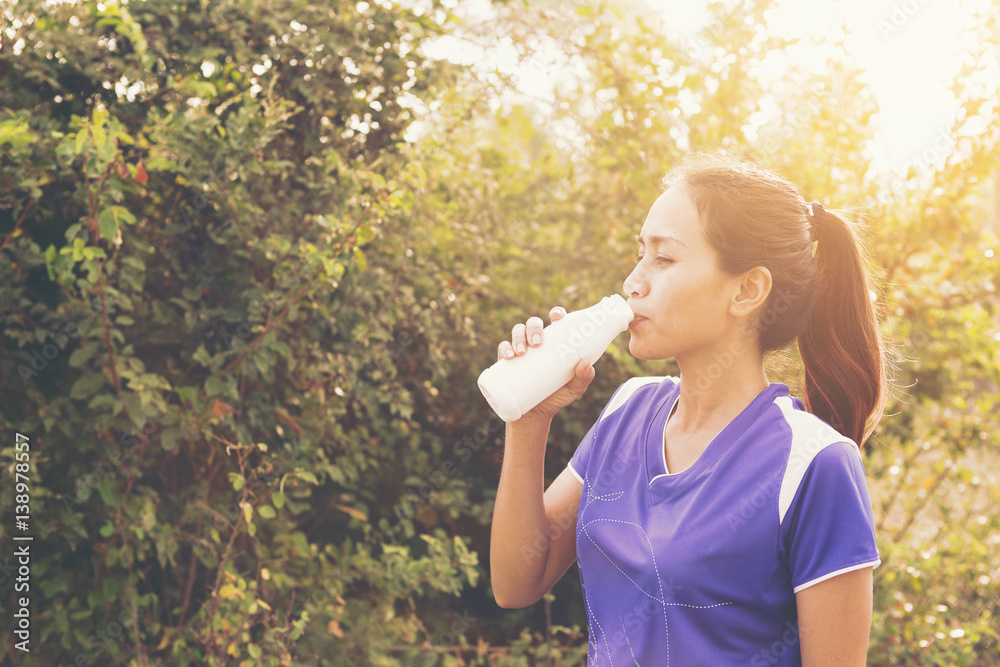 Beautiful sport woman drinking milk or female athletes drink milk after exercise. StockFoto