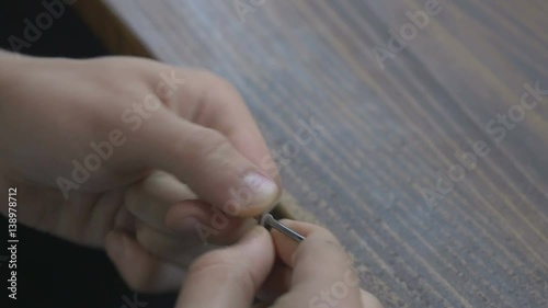 Close-up - the man making a spring for the vape photo