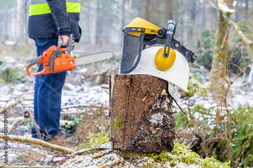 Helmet with mask and hearing protection earmuffs on the stump