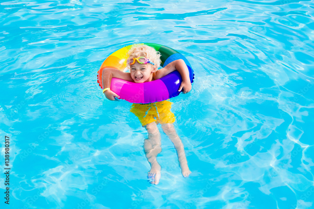Child with toy ring in swimming pool
