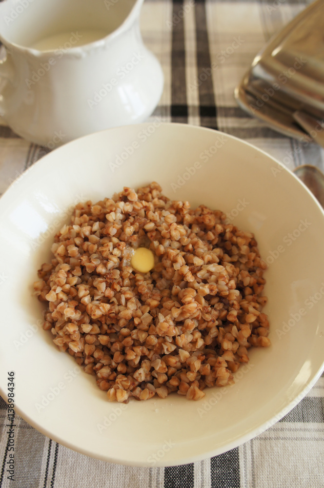 Breakfast on checked table-cloth boiled buckwheat with butter vertical. Breakfast on checked table-cloth boiled buckwheat with butter vertical.