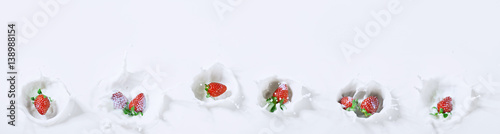 delicious panoramic view of strawberries sinking down into milk with a drops