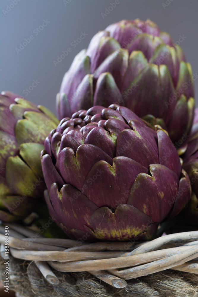 Obraz premium Fresh big Romanesco artichokes green-purple flower heads ready to cook