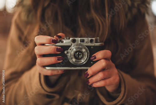 Принти на полотні Hipster girl with retro camera taking photos outdoors