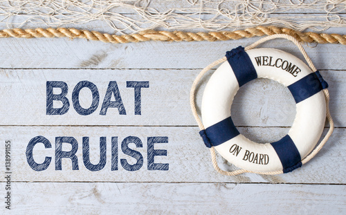 Fototapeta Boat Cruise - Welcome on Board - lifebuoy with text on wooden background