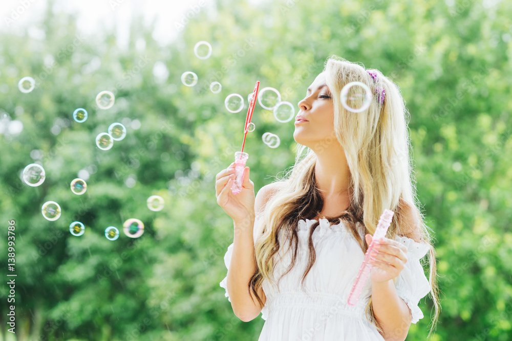 Young and beautiful girl making soap bubbles outdoors. Young and beautiful girl making soap bubbles outdoors.