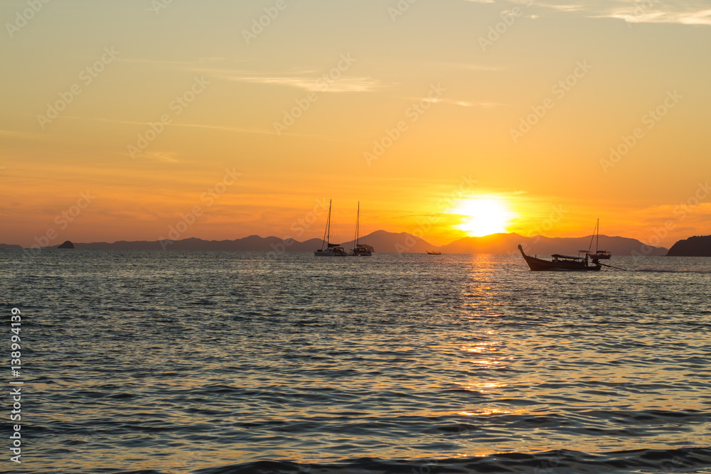 Sunset and traditional thai long boat around seaside, Ao Nang, Krabi province, Thailand