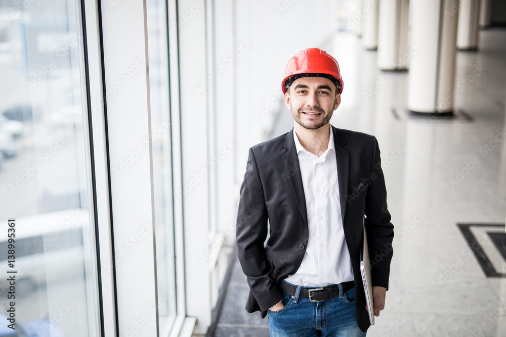 Engineer in hardhat with laptop computer, smiling at camera. Engineer in hardhat with laptop computer, smiling at camera.