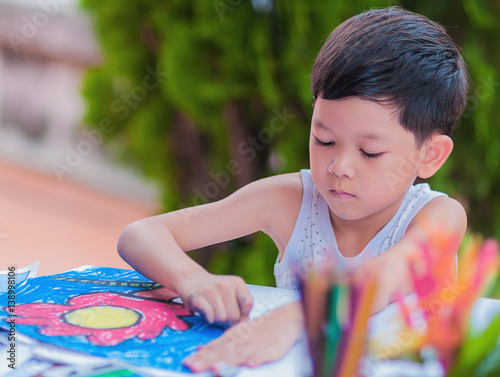 Boy is painting colorful picture at home. Photo is focused at his eyes.