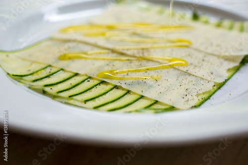 Courgette carpaccio on plate with drizzle of dressing