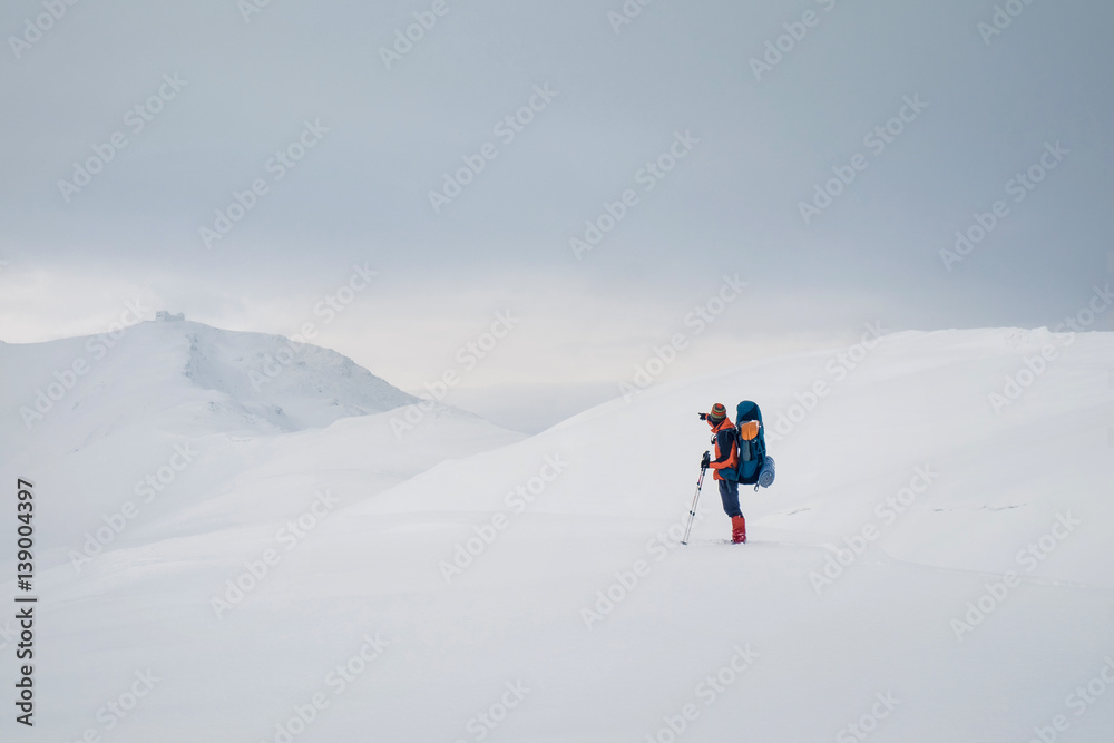 Man hiking with backpack and snowshoes in beautiful mountain
