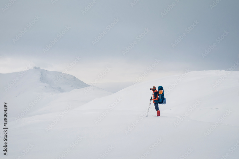 Man hiking with backpack and snowshoes in beautiful mountain Man hiking with backpack and snowshoes in beautiful mountain
