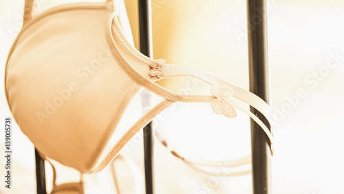 A bra hangs over a metal bed - passion or loneliness?