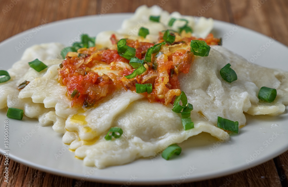 Ravioli with tomato sauce on a wooden background Ravioli with tomato sauce on a wooden background