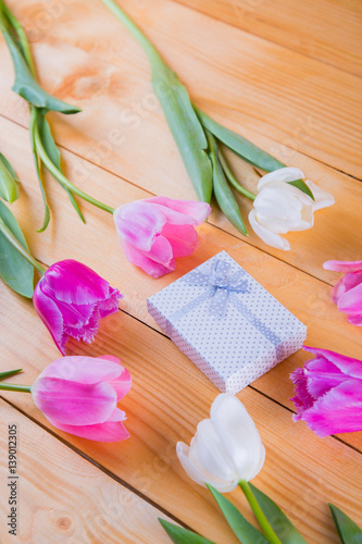 Fototapeta Naklejka Na Ścianę i Meble -  Bouquet of tender pink tulips with gift box on light wooden background