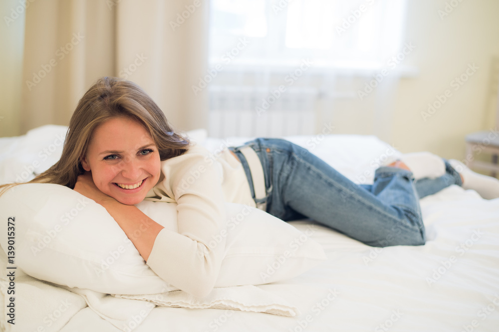 Smiling thoughtful pretty woman lying in bed at home Smiling thoughtful pretty woman lying in bed at home
