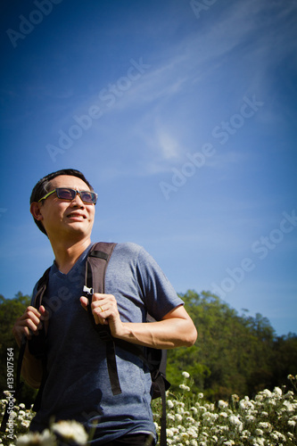 Asia man backpack travel in nature background blue sky.