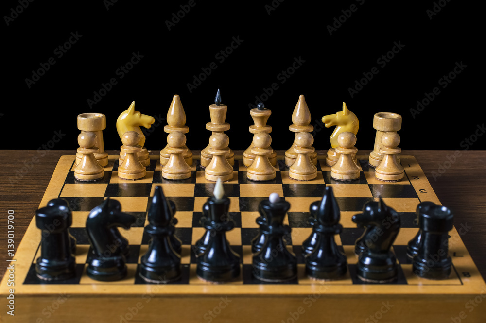 game of chess figures stand on the positions of, isolated black background game of chess figures stand on the positions of, isolated black background
