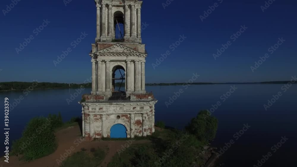 The famous bell tower in Kalyazin on the river Volga. Old steeple sticking out in the middle of the river. Summer day, sunny. Aerial shot.