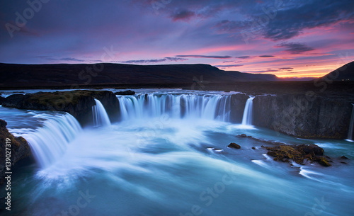 Stunning sunset over Godafoss Waterfall with smooth flowing in Iceland