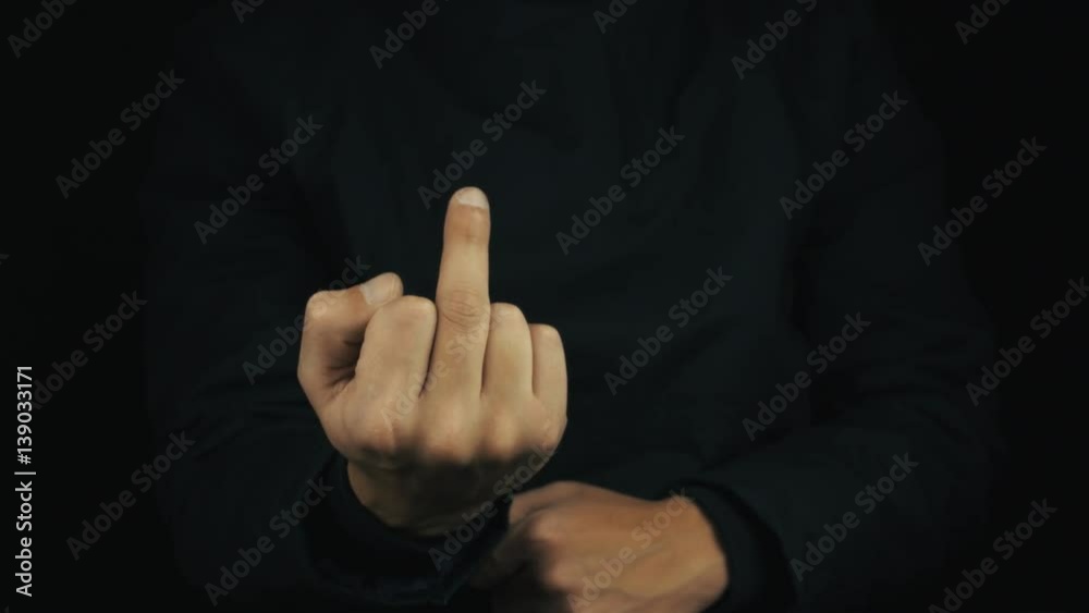 Caucasian male hand in long sleeve jacket push button make middle fing flip up obscene sign gesture on black background, close up isolated Caucasian male hand in long sleeve jacket push button make middle fing flip up obscene sign gesture on black background, close up isolated