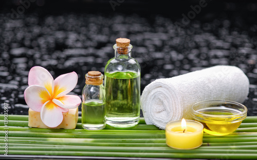tranquil spa scene- towel with black stones with candle  green plant towel