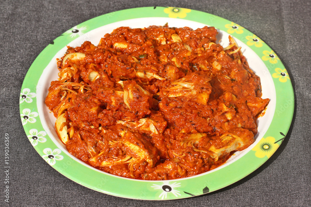 Kathal ki Masaledar Sabzi (spicy jackfruit curry) in a plate on black background. Kathal ki Masaledar Sabzi (spicy jackfruit curry) in a plate on black background.