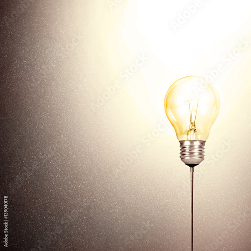 Light bulb on stone wall background