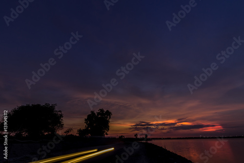 Panorama view with colourful sunset and twilight sky,, tropical island Bali, Indonesia. Dark scene with car and motorbikes lights.
