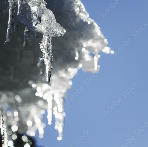 shiny icicles melt and drip on the roof in the spring