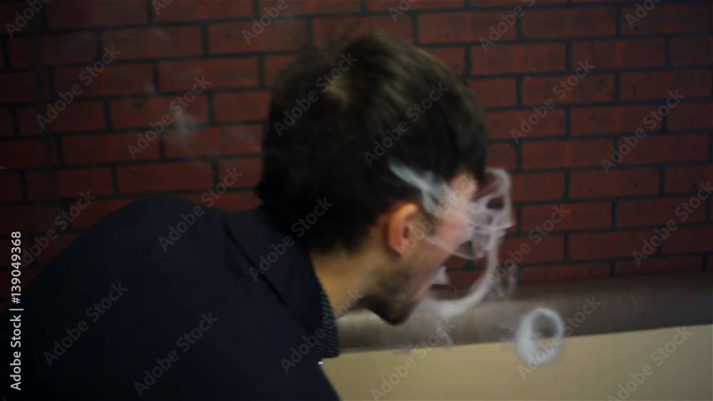 Young handsome white guy lets rings out of steam with electronic cigarette. Vaping. Young handsome white guy lets rings out of steam with electronic cigarette. Vaping.