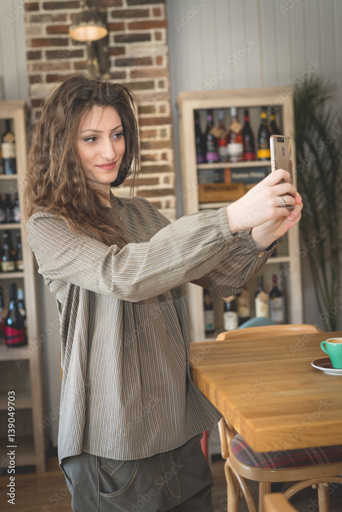 Young woman in restaurant talkin on the phone Young woman in restaurant talkin on the phone