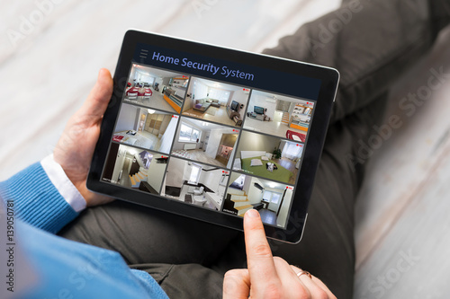 Man looking at home security cameras on tablet computer