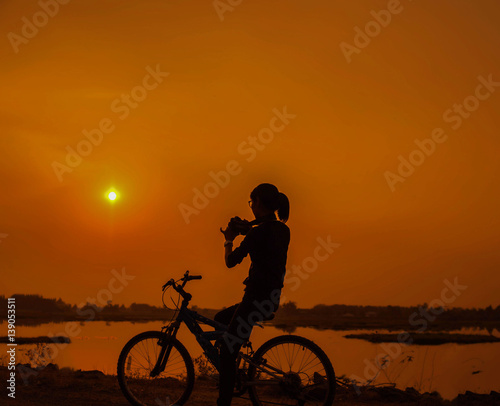 Woman biking hands at sunset