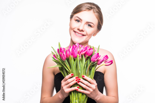 Portrait of beautiful young woman with long hair and glamour makeup. Girl holding tulips. Studio shot.